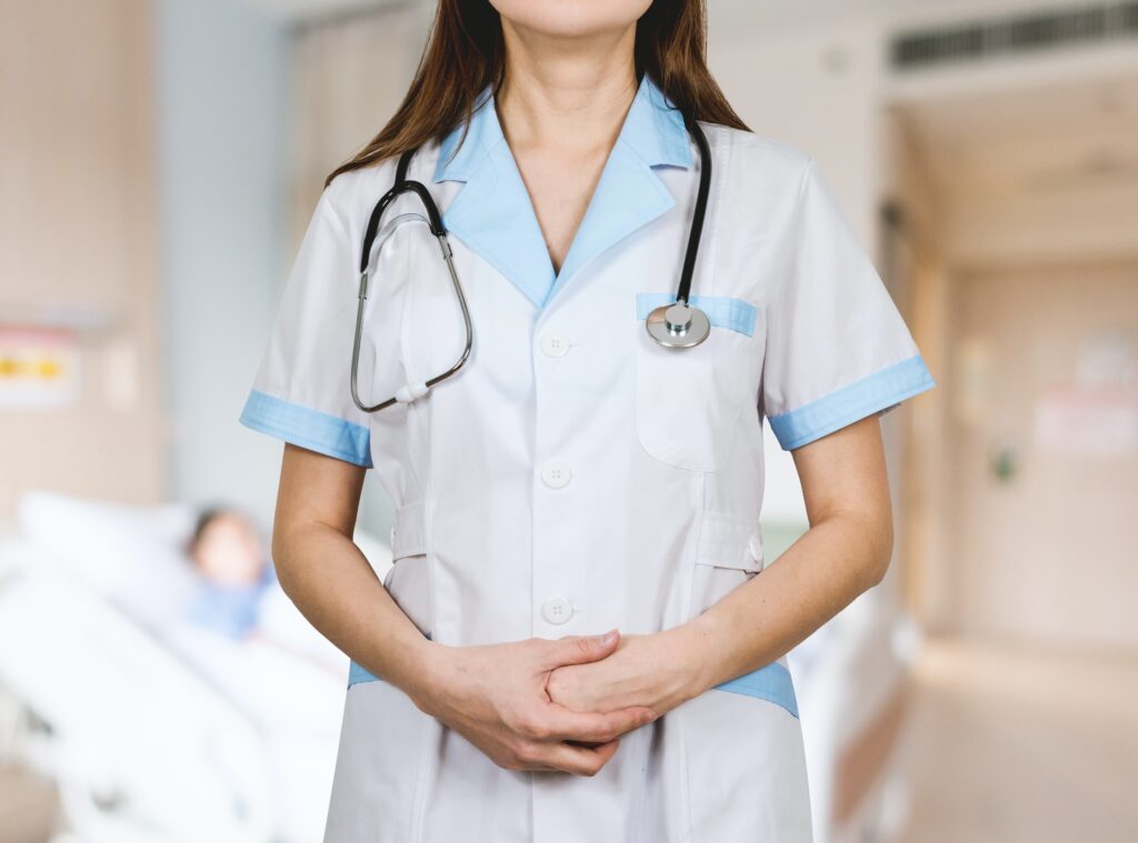 woman in white button up shirt with stethoscope around her neck